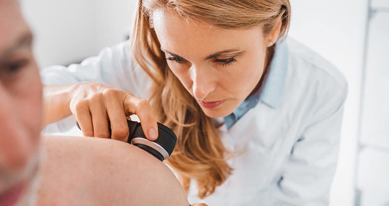 dermatologist inspecting the skin of a patient.
