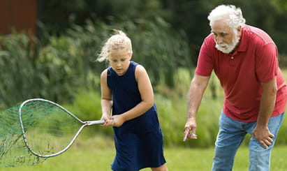 Grandfather and granddaughter catching butterflies