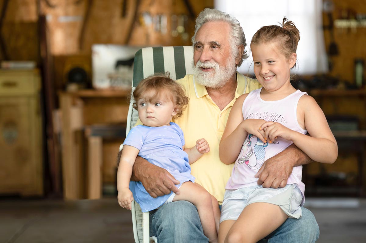 A mother holding her child consults a phone and laptop