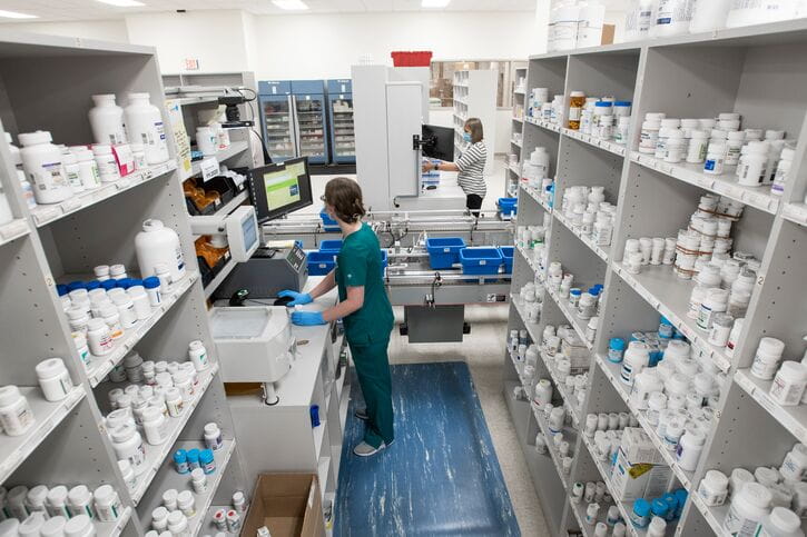 Pharmacy shelves and a pharmacist