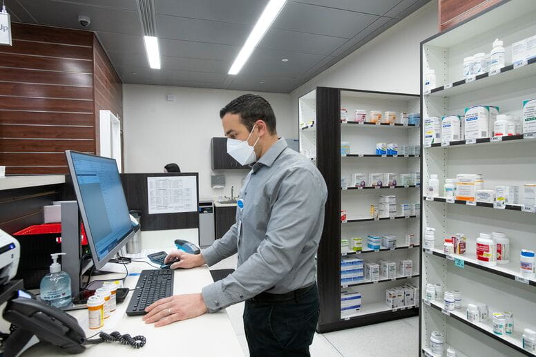 Pharmacist standing at a computer