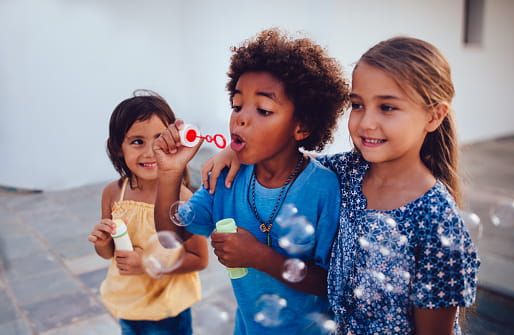 an image of 3 girls blowing bubbles