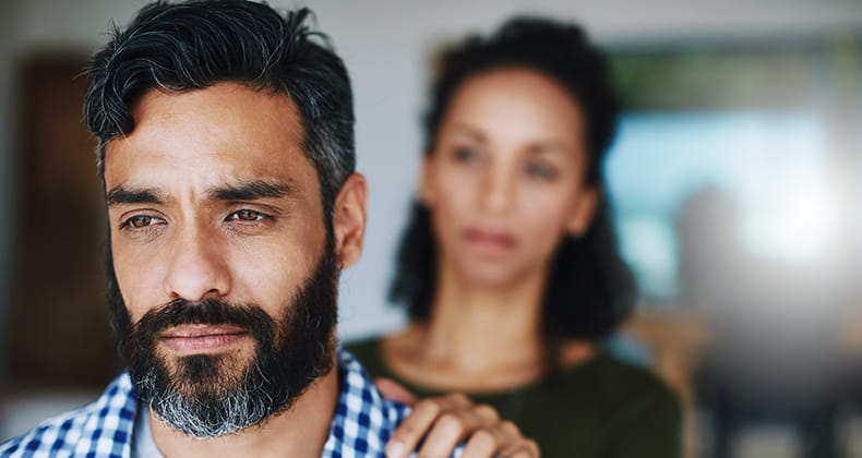 A woman comforting her distraught husband.