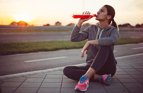 A woman drinking electrolytes after a workout