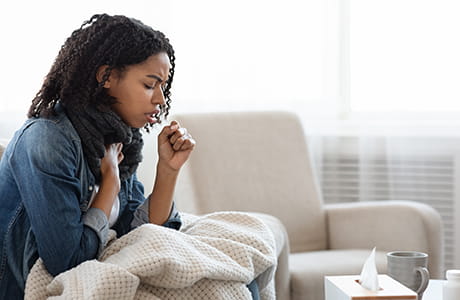 A sick woman sitting on a couch.