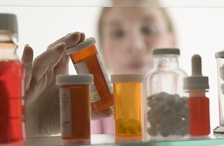 A woman looking at prescription medicines.