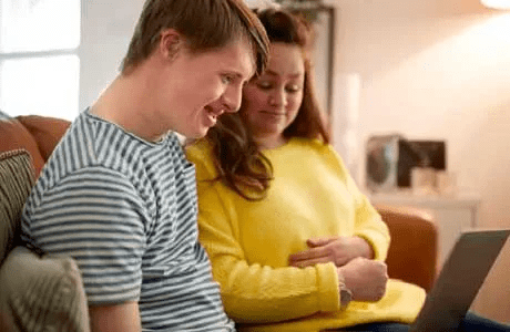 Una mujer y su hijo miran una computadora portátil