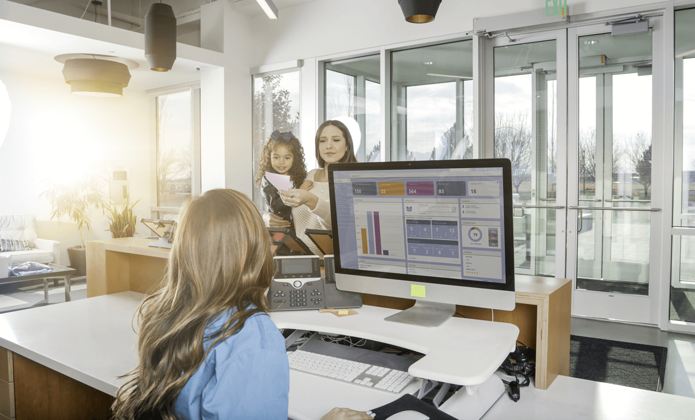 Una mujer habla con una empleada en la recepción de una clínica