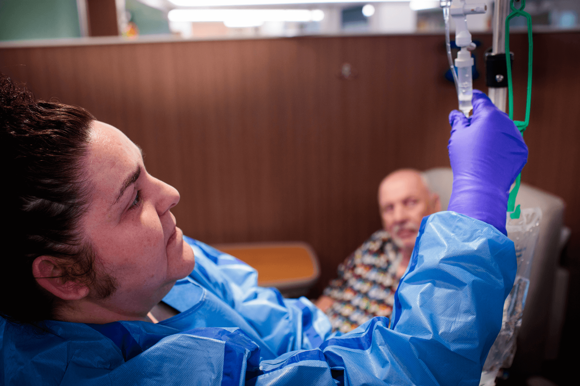 Un miembro del personal de enfermería revisa una vía intravenosa de un paciente