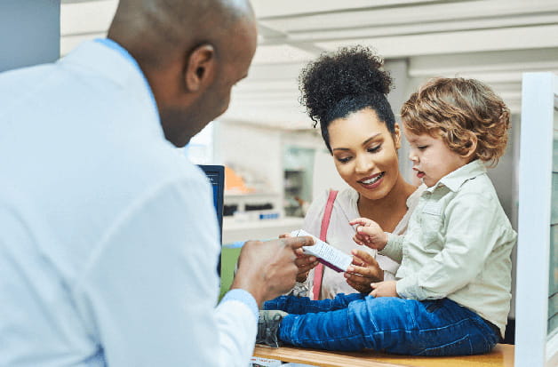 Parent picking up a prescription with their kids