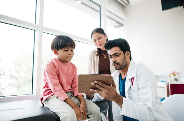 Un médico analiza los resultados con un niño en una sala de examen